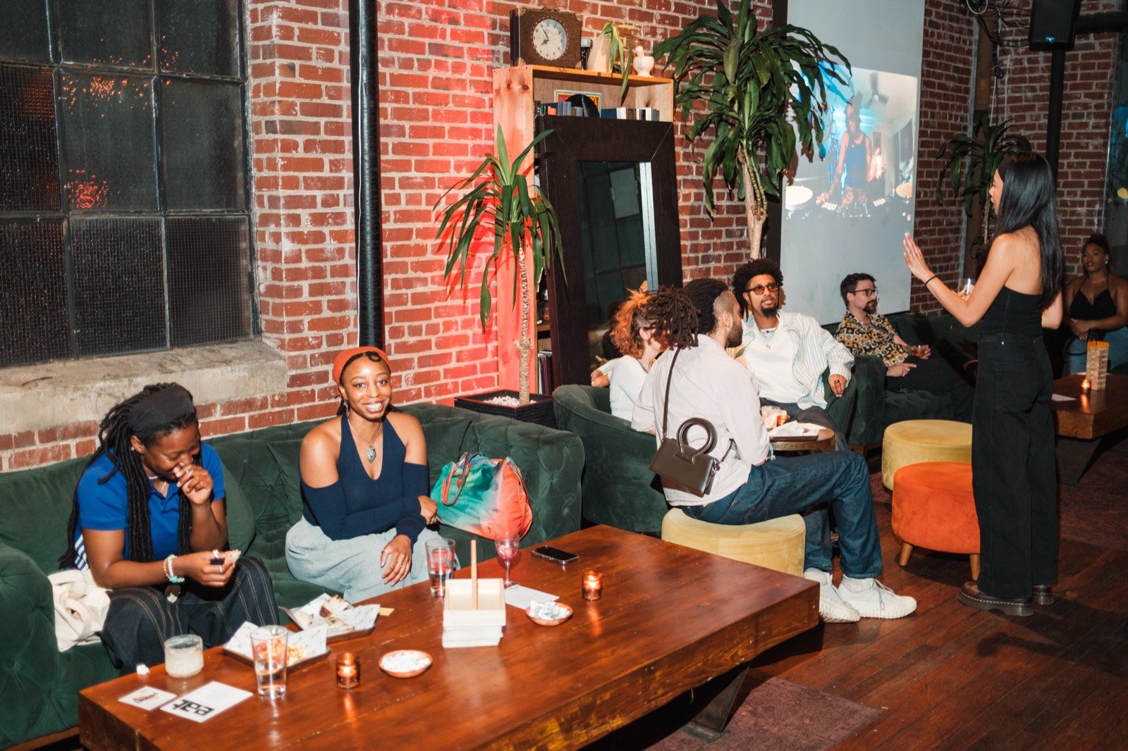 The vol. 1 room — brick walls, plants, and guests settled into the couches